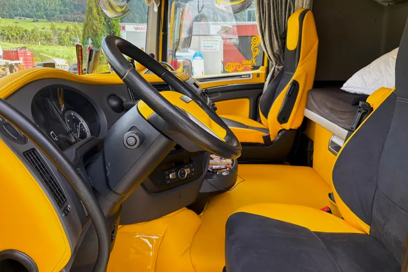 Hand legt einen bezogenen Armaturenbrettbezug an einer Fahrzeugkonsole an